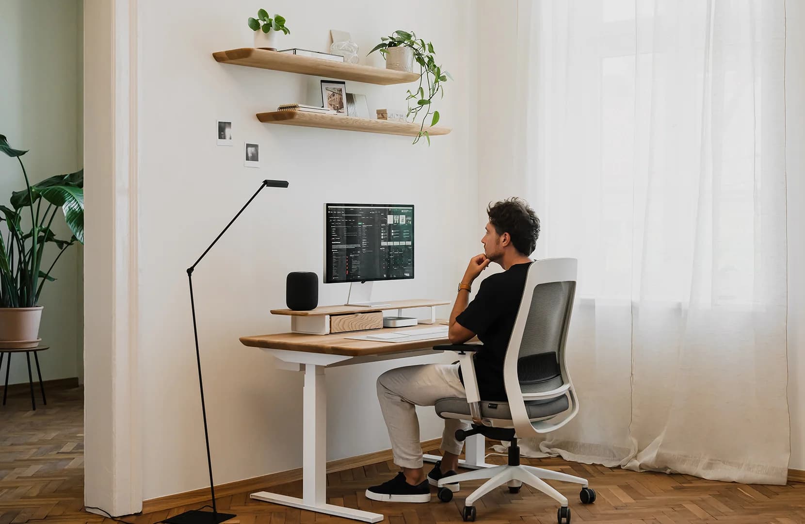 Modern workspace with a desk, ergonomic chair, shelves and storage cabinet