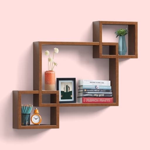 Walnut interlocking box wall shelf holding books, a clock and small decor